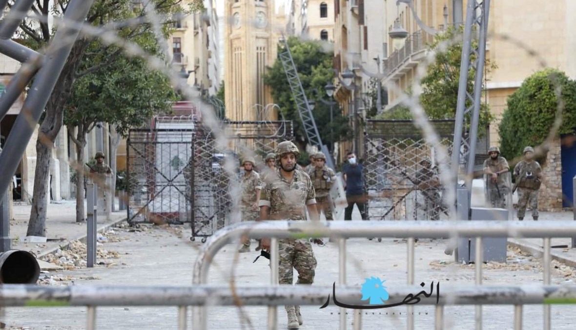 عناصر من الجيش وراء الشريط الشائك أمام أحد مداخل المجلس النيابي في بيروت. 