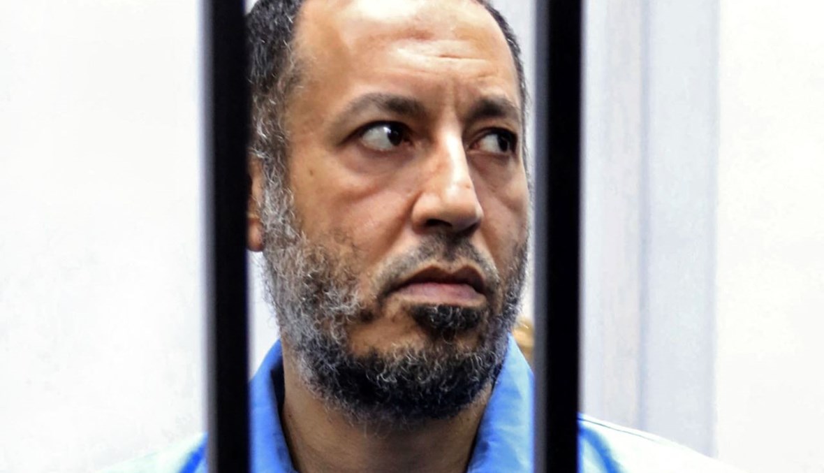 الساعدي القذافي يجلس في زنزانة الاتهام خلال محاكمته في محكمة بالعاصمة الليبية طرابلس (6 ك1 2016، أ ف ب). 