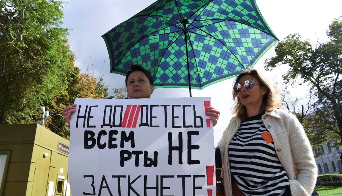 امرأة تحمل لافتة كتب عليها "لا يمكن أن تسكتوا الجميع!"، خلال مشاركة صحافيين في احتجاج على وضع وسائل إعلام في قائمة "العملاء الأجانب"، وسط موسكو (4 أيلول 2021، أ ف ب). 