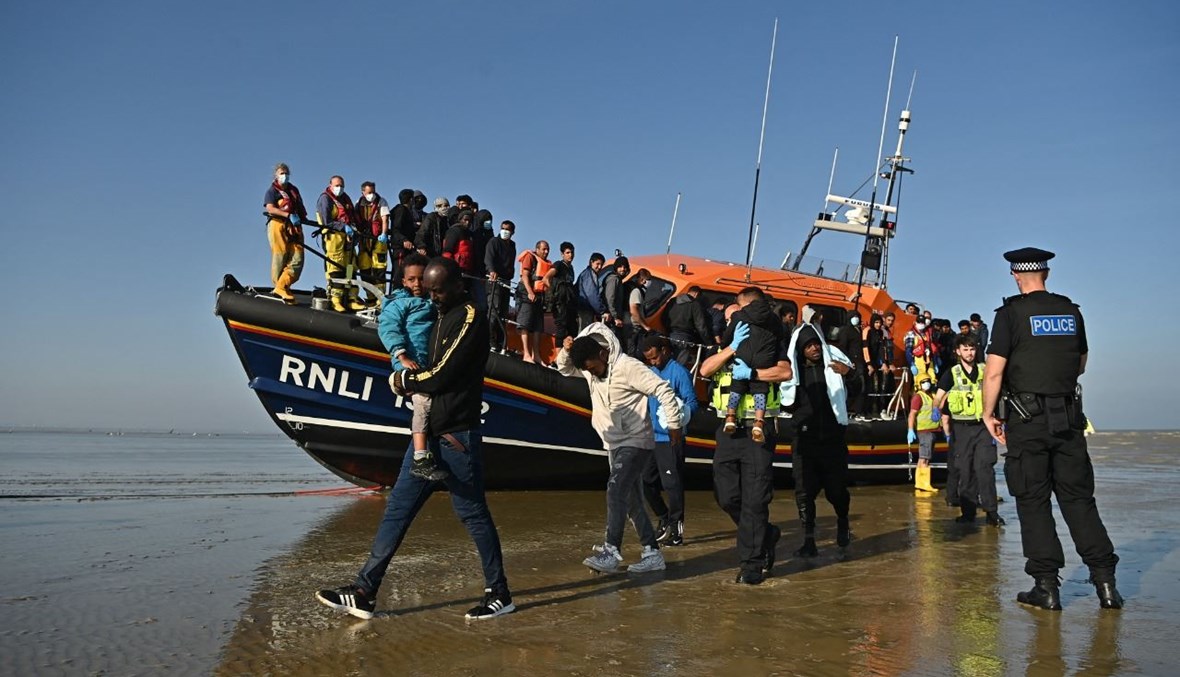 مهاجرون يصلون الى شاطئ في دانجينيس جنوب شرق بريطانيا، بعدما انقذهم مركب تابع للمؤسسة الملكية الوطنية، خلال عبورهم القناة الإنكليزية (7 ايلول 2021، ا ف ب). 