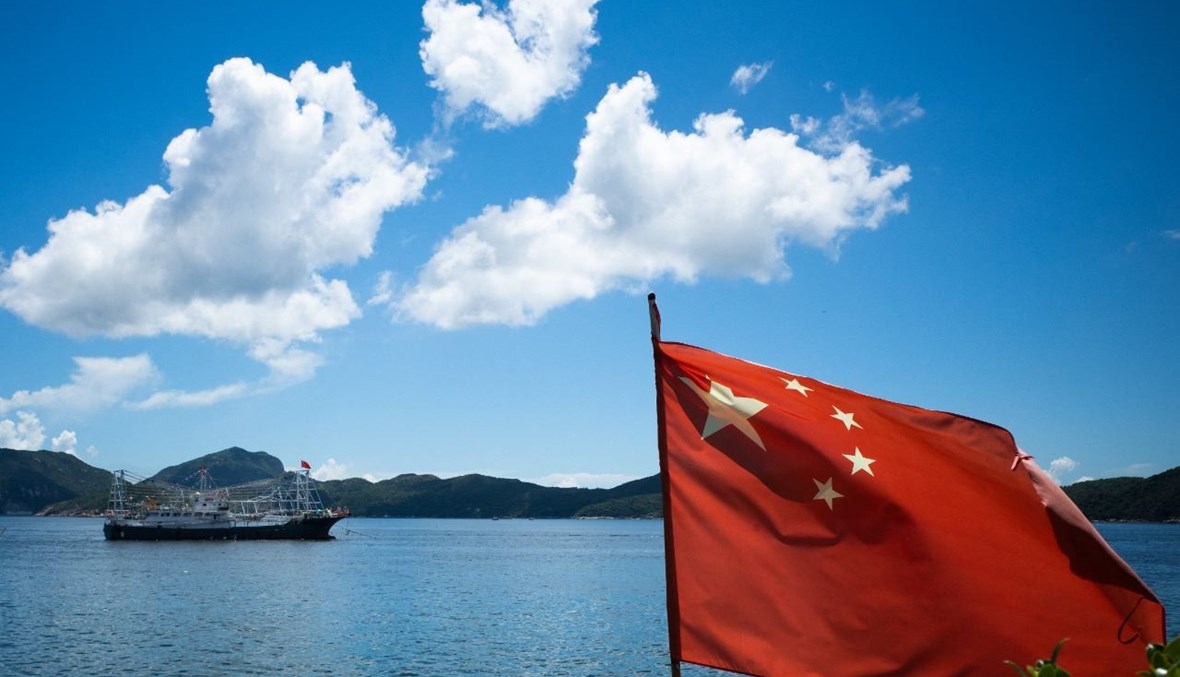 علم الصين يرفرف بينما يبحر قارب في مياه هونغ كونغ (4 أيلول 2021، أ ف ب). 