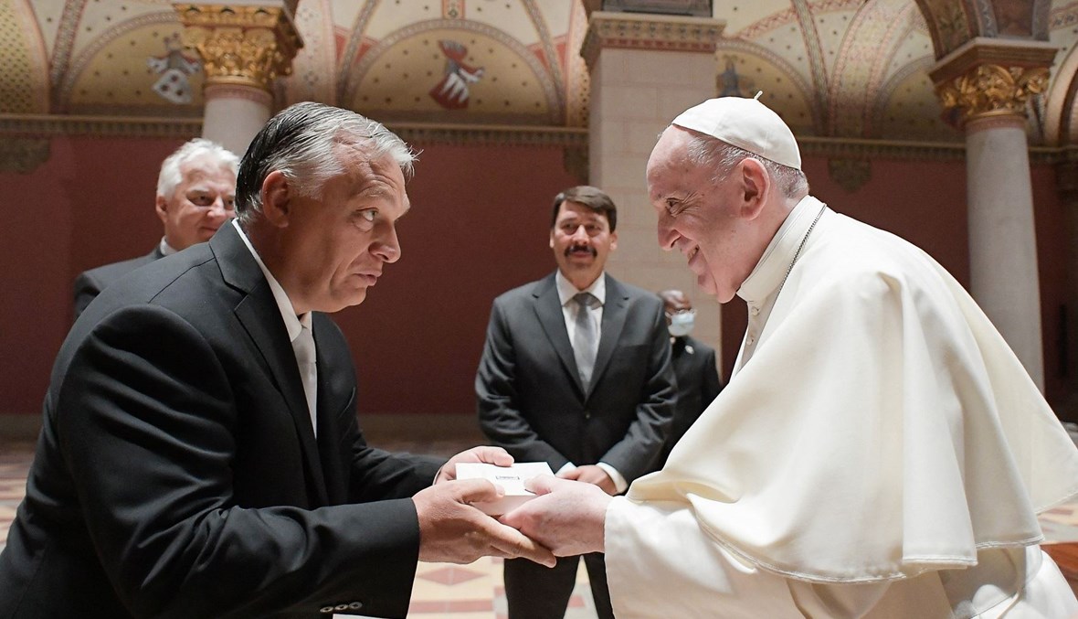 البابا فرنسيس مصافحاً رئيس الوزراء المجري فكتور أوربان (أ ف ب).
