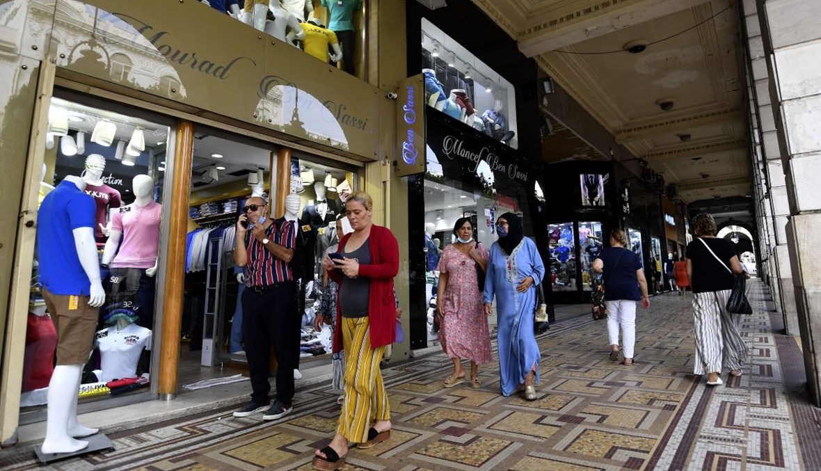 تونسيون يمشون في أحد شوارع التسوق في تونس العاصمة (23 ايلول 2021، أ ف ب). 