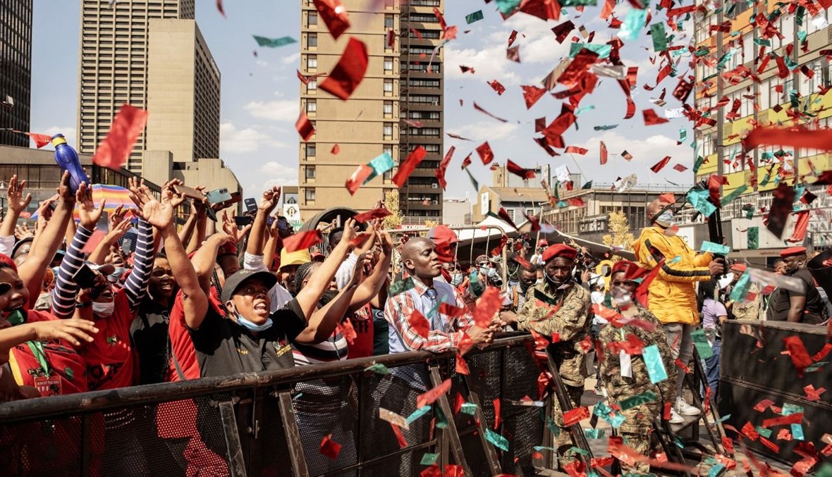 أنصار حزب "مناضلون من أجل الحرية الاقتصادية" يغنون ويرقصون في جوهانسبرغ قبل تلاوة بيان الحزب للانتخابات المحلية المقبلة (26 ايلول 2021، أ ف ب). 
