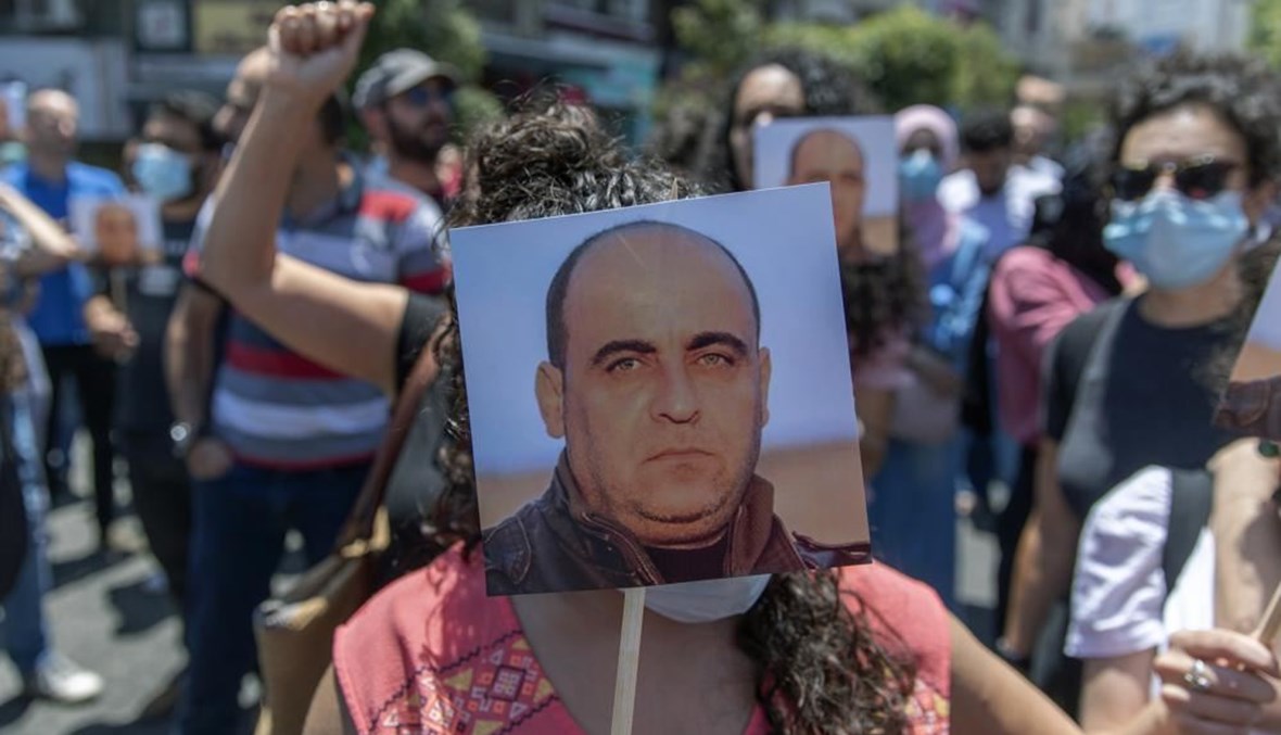 متظاهرون حملوا صور نزار بنات خلال احتجاج مناهض للسلطة الفلسطينية في رام الله بالضفة الغربية (24 حزيران 2021، أ ب). 