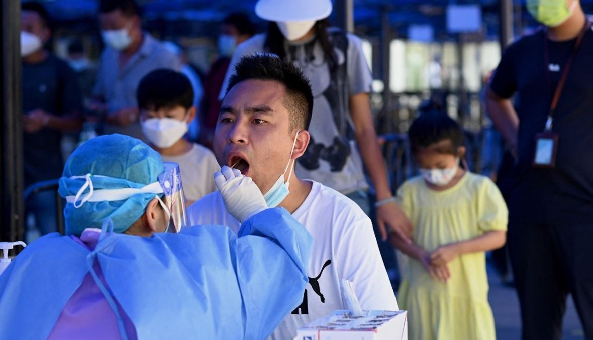 عامل صحي يأخذ مسحة من رجل في محطة قطارات تشوهاي في تشوهاي بمقاطعة قوانغدونغ جنوب الصين (27 ايلول 2021، أ ف ب). 