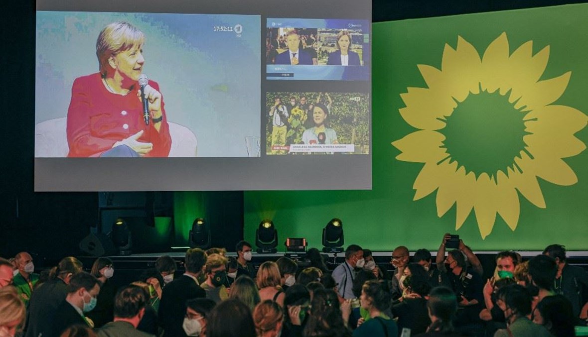 لقطة لميركل على الشاشة أمام حشد لمناصري حزل الخضر في ألمانيا (أ ف ب).