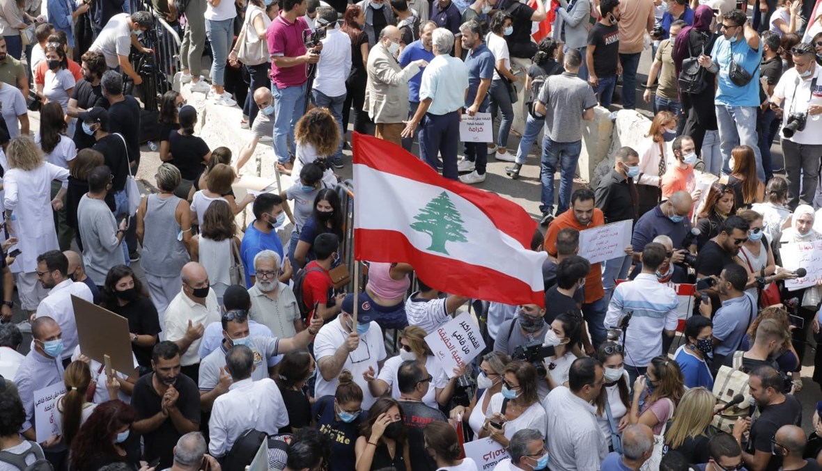 العلم اللبناني مرفوع وسط تظاهرة أمام قصر العدل في بيروت اليوم (مارك فياض).