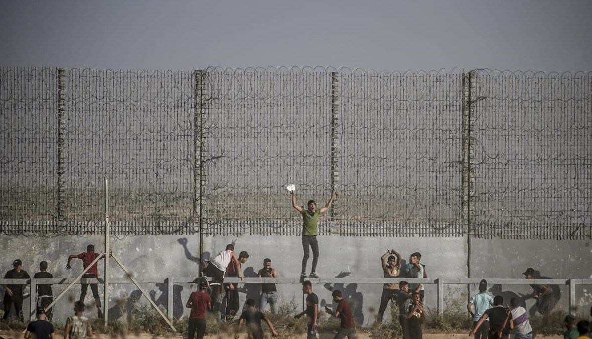 فلسطينيون عند السياج الحدودي (أ ف ب).