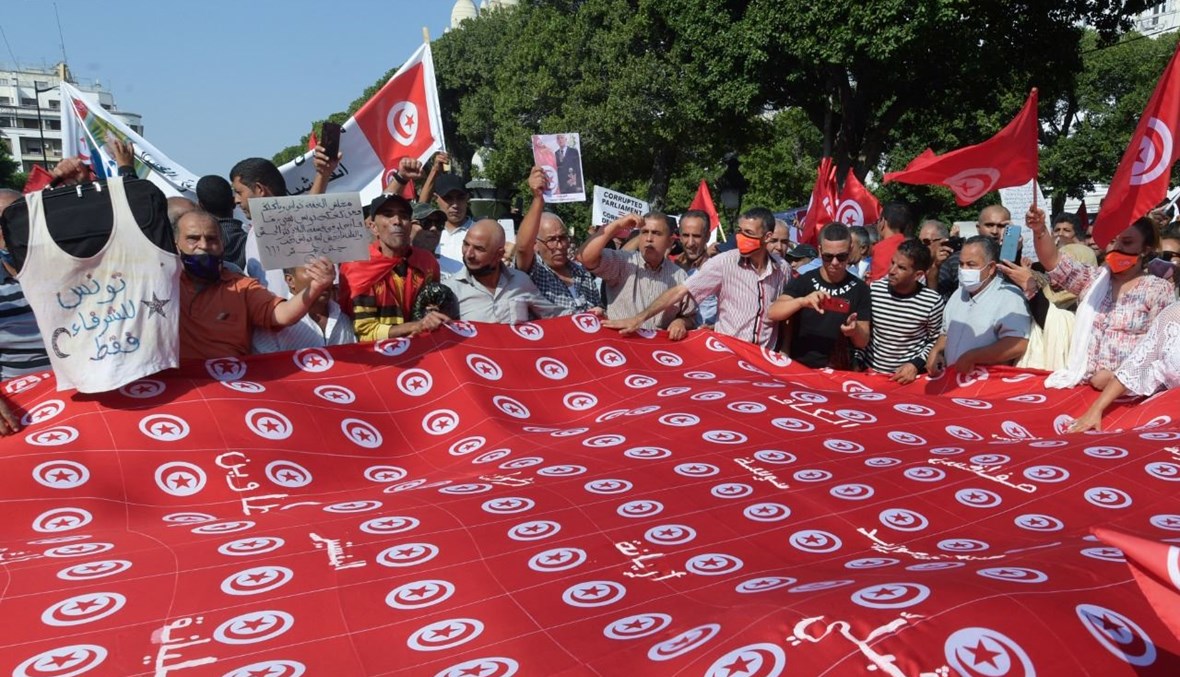 تونسيون يرددون شعارات مؤيدة للرئيس سعيد خلال تجمع حاشد في شارع الحبيب بورقيبة بالعاصمة تونس (3 ت1 2021، أ ف ب).