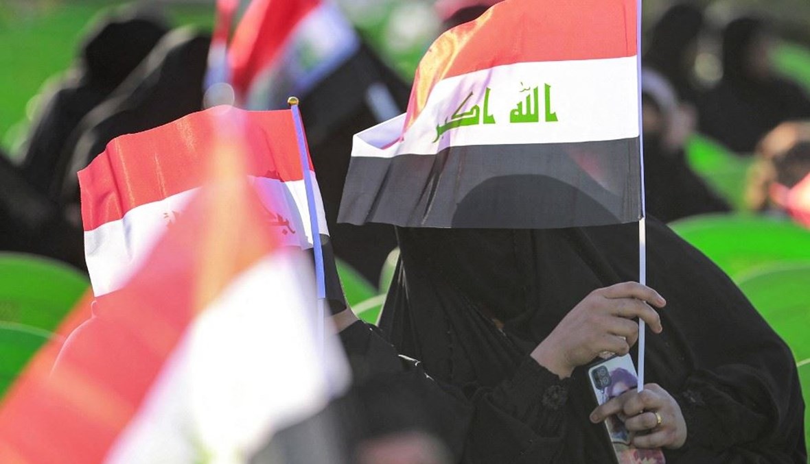 العلم العراقي مرفوعاً خلال تجمّع انتخابي في العاضمة بغداد (أ ف ب).
