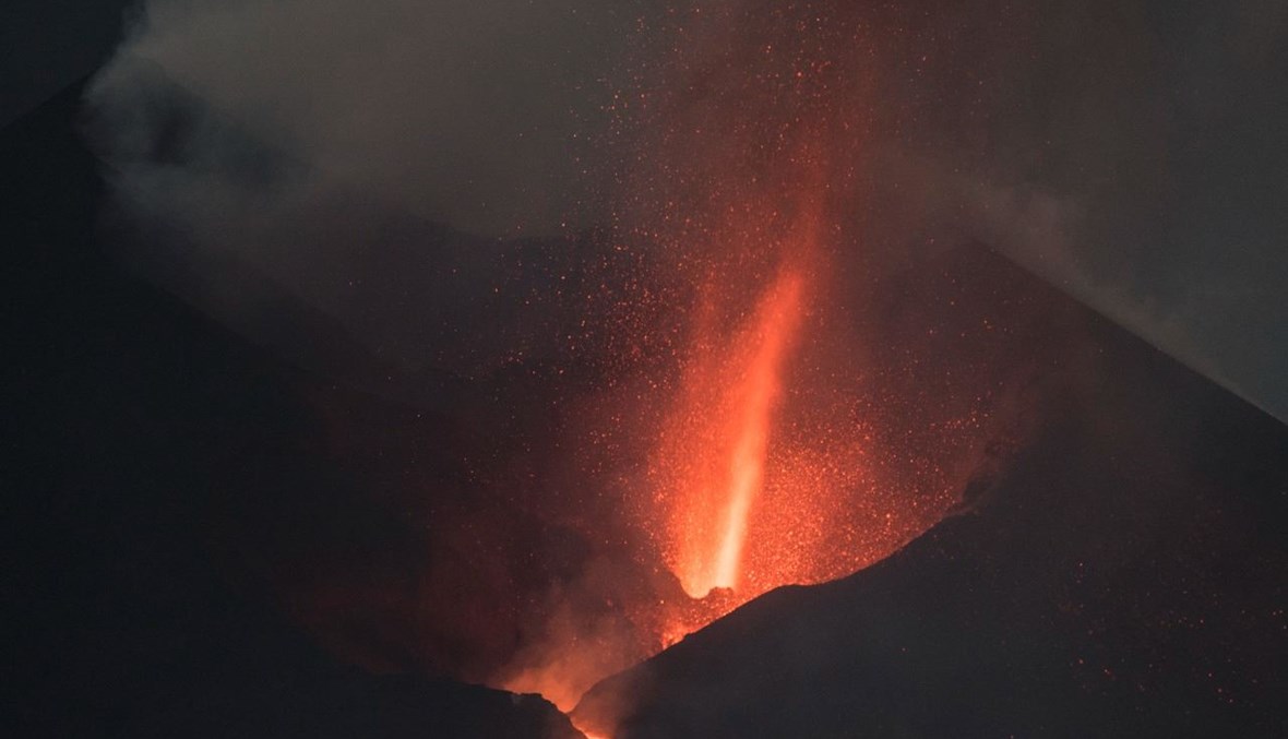 بركان كومبري بييخا يقذف الحمم والرماد والدخان في جزيرة لا بالما ليلًا (10 ت1 2021، أ ف ب). 
