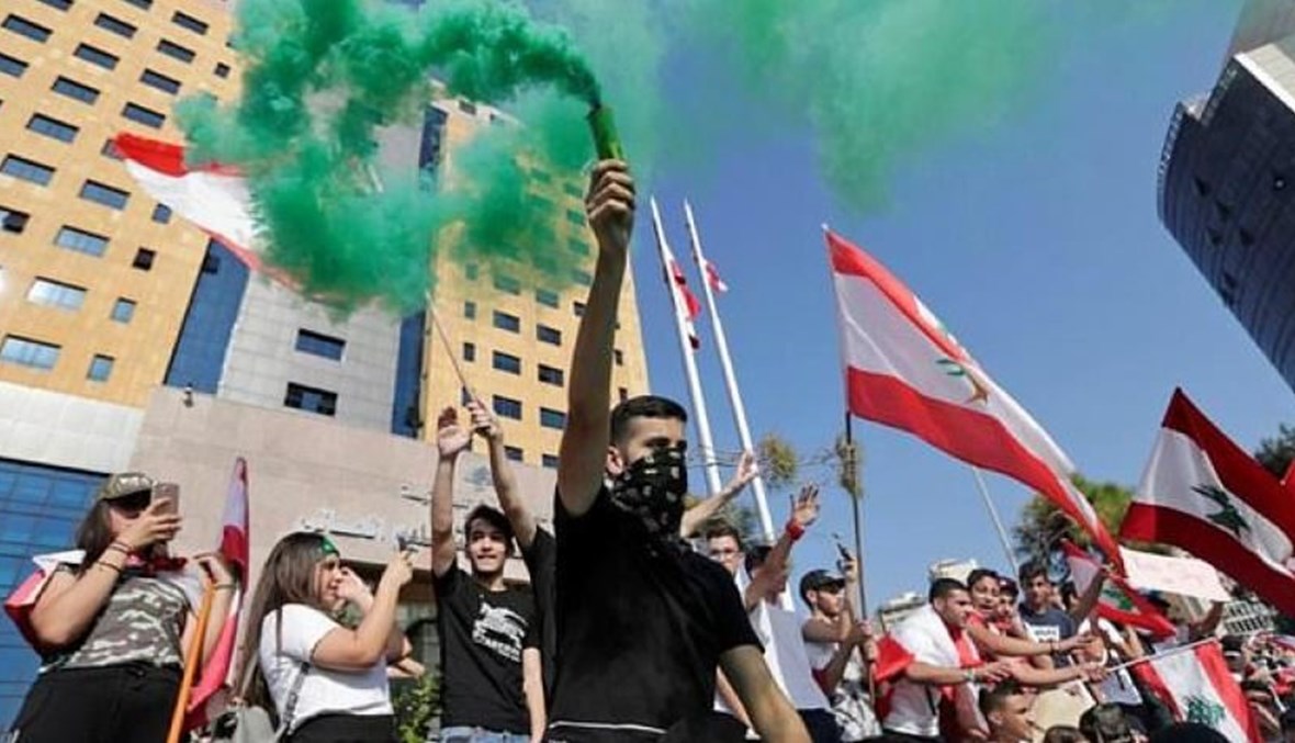 Lebanese school students wave the national flag and flares as they protest outside the education ministry in Beirut. (AFP)