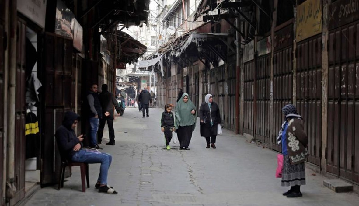 People walk past closed shops in Lebanon’s northern port city of Tripoli, on January 26, 2021. (AFP)