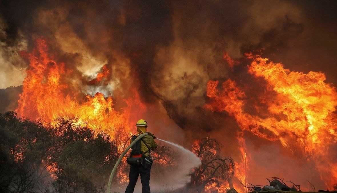 رجل إطفاء يحاول إخماد النيران في كاليفورنيا (أ ف ب).
