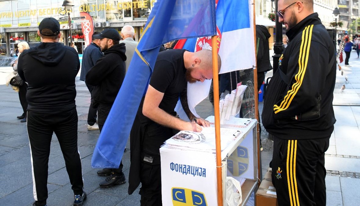 رجل يوقع عريضة في بلغراد تطالب بالإفراج المبكر عن زفيزدان يوفانوفيتش (3 ت1 2021، أ ف ب). 