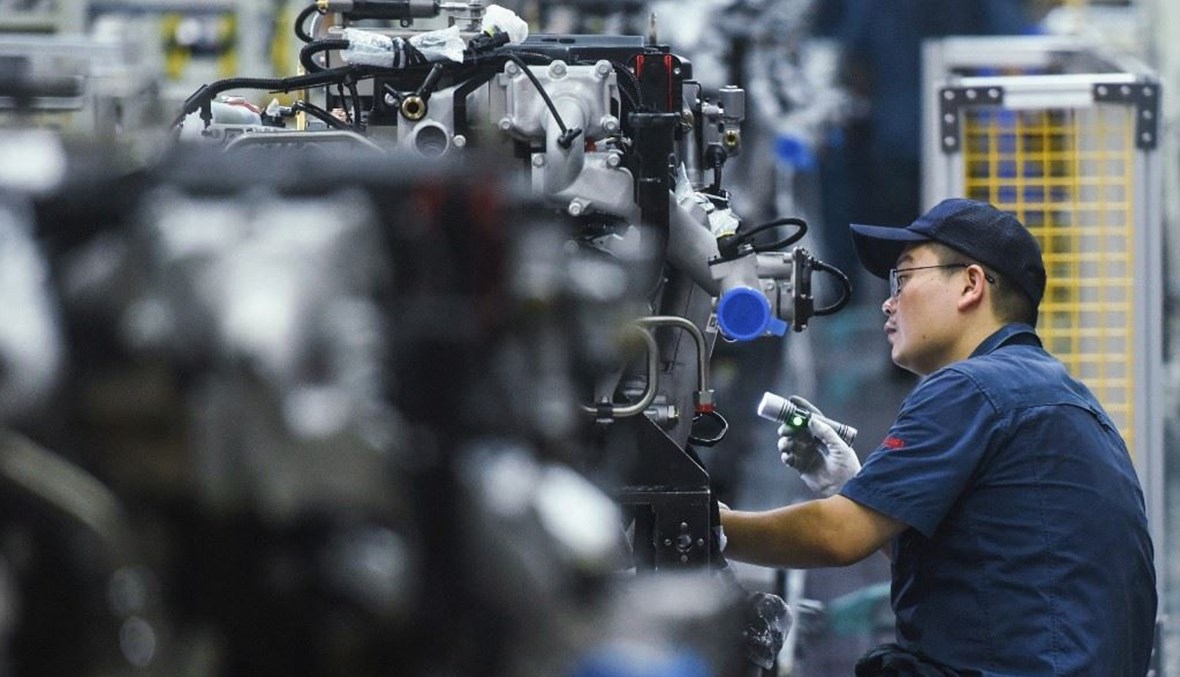 عامل ينتج محركات شاحنات في مصنع بمدينة هانغتشو في مقاطعة تشجيانغ شرقي الصين (أ ف ب).