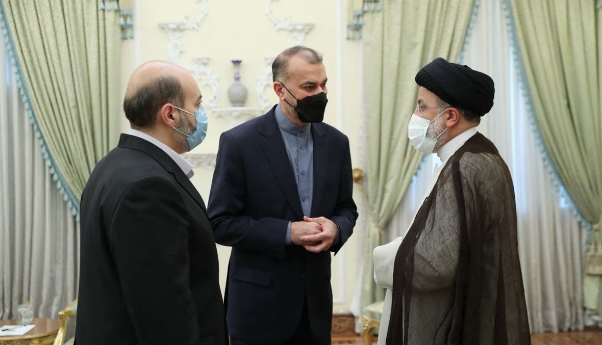 رئيسي (إلى اليمين) يتحدث الى وزير الخارجية الإيراني حسين أمير عبد اللهيان (في الوسط) في طهران (18 ت1 2021، أ ف ب).