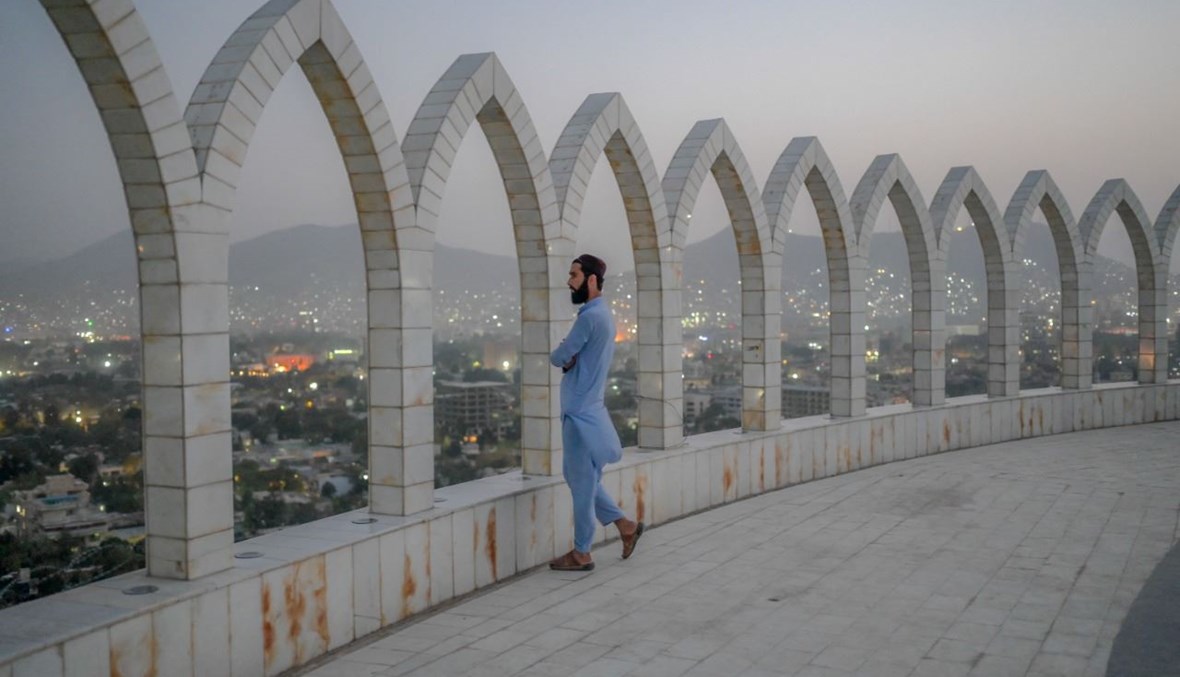 عنصر من طالبان ينظر الى كابول من أعلى مبنى (20 ت1 2021، أ ف ب). 