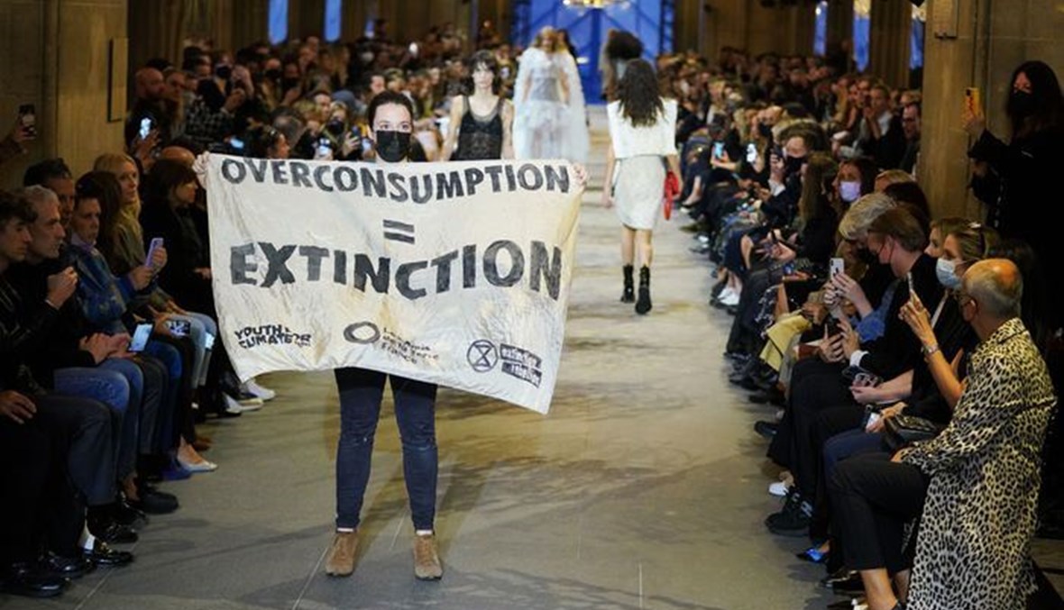 ناشطة بيئية تقتحم عرض ازياء لوي فويتون خلال أسبوع الموضة في باريس في باريس (5 ت1 2021، ا ف ب).