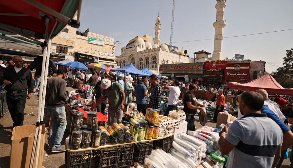 فلسطينيون يتسوقون في سوق شعبية في وسط مدينة رام الله بالضفة الغربية المحتلة (15 ت1 2021، أ ف ب). 