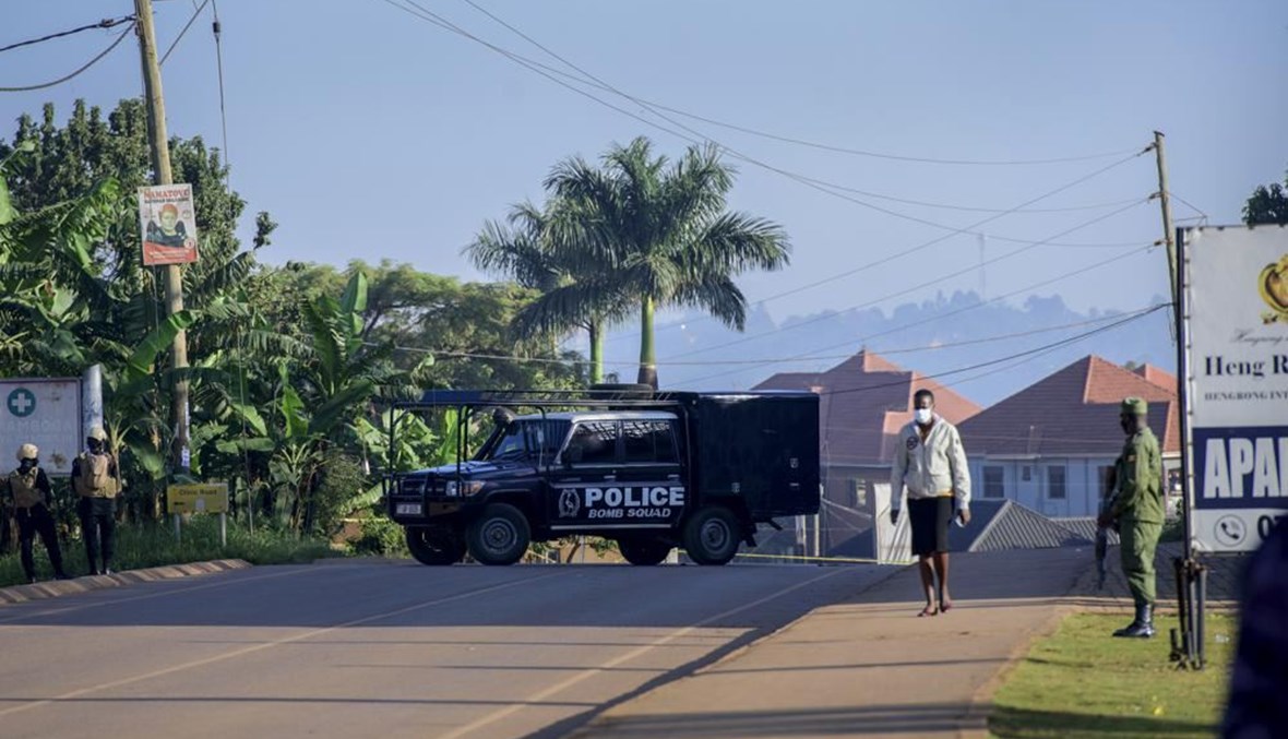 سيارة تابعة للشرطة توقفت على الطريق المؤدي إلى موقع انفجار في ضاحية كومامبوغا بالعاصمة كمبالا (24 ت1 2021، أ ب). 