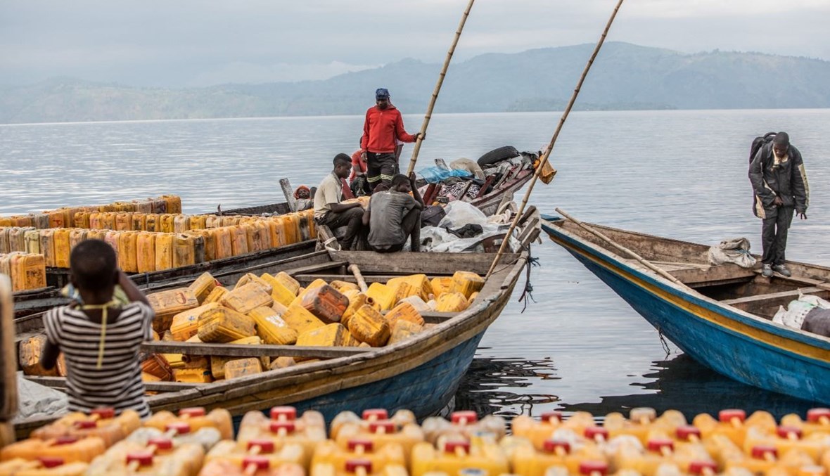 صورة تعبيرية- تجار يفرغون بضائعهم في زورق على ضفاف بحيرة كيفو في غوما (21 ت1 2021، أ ف ب). 