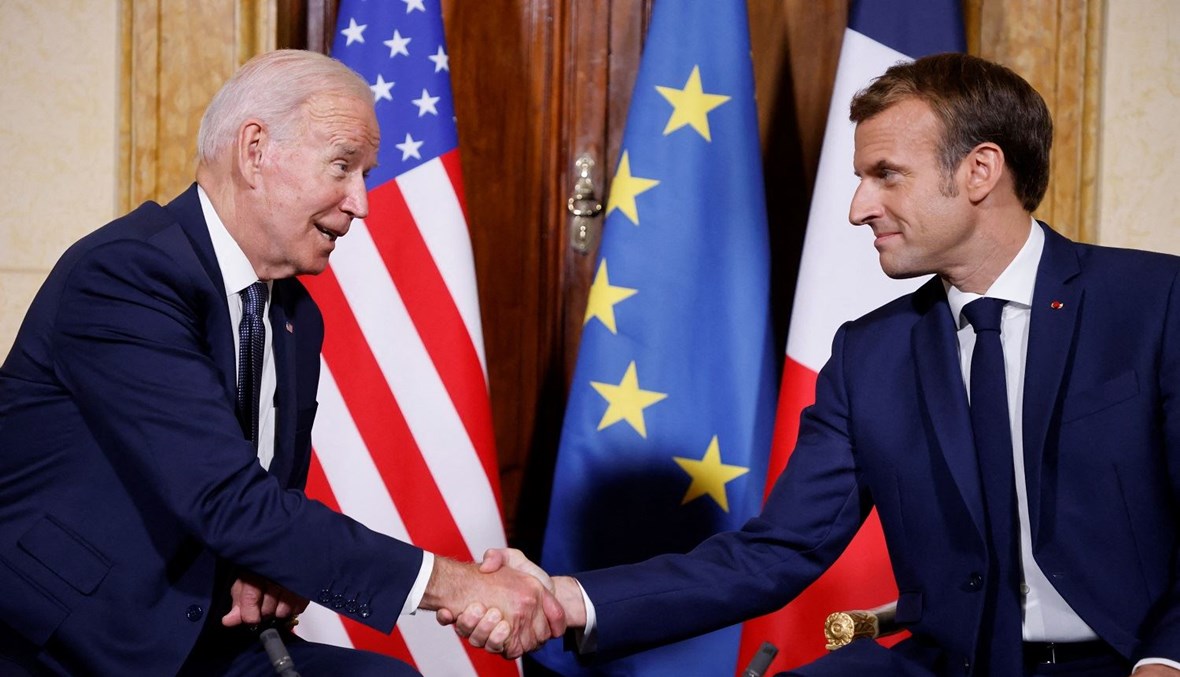 الرئيسان الأميركي والفرنسي جو بايدن وإيمانويل ماكرون يتصافحان قبل عقد اجتماعهما على هامش أعمال قمة مجموعة العشرين في روما (أ ف ب).