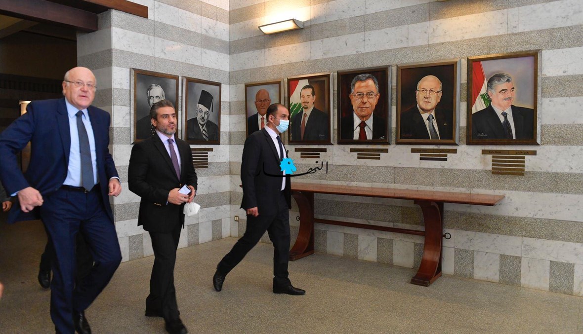 الرئيس نجيب ميقاتي ويبدو إلى جانبه الأمين العام لمجلس الوزراء محمود مكية، وفي الخلفية صور رؤساء الحكومات السابقين في السرايا (حسام شبارو).