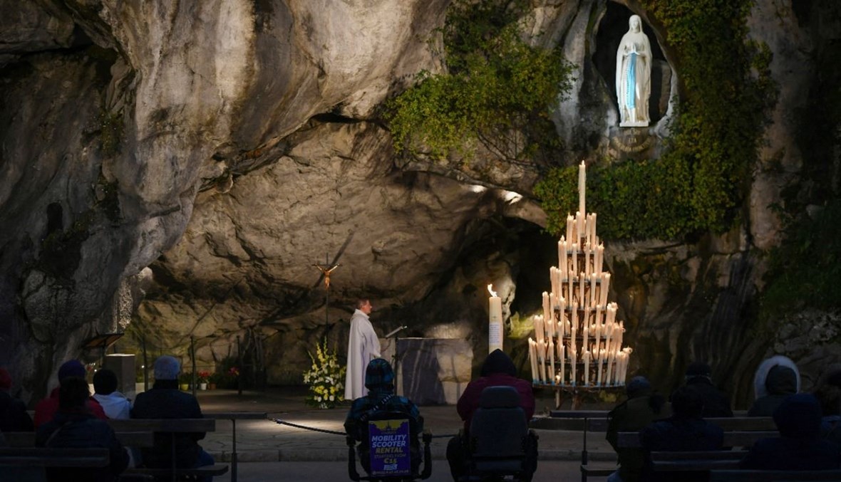 مؤمنون يشاركون في قداس في مغارة ماسابييل في مزار السيدة في لورد جنوب غرب فرنسا (2 ت2 2021، أ ف ب). 