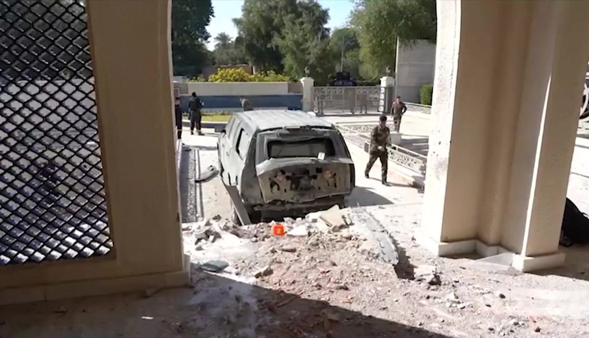 عناصر من قوات الأمن العراقية وقفوا قرب مركبة تضررت من جراء  الهجوم على مقر إقامة رئيس الوزراء في بغداد (7 ت2 2021، أ ف ب). 