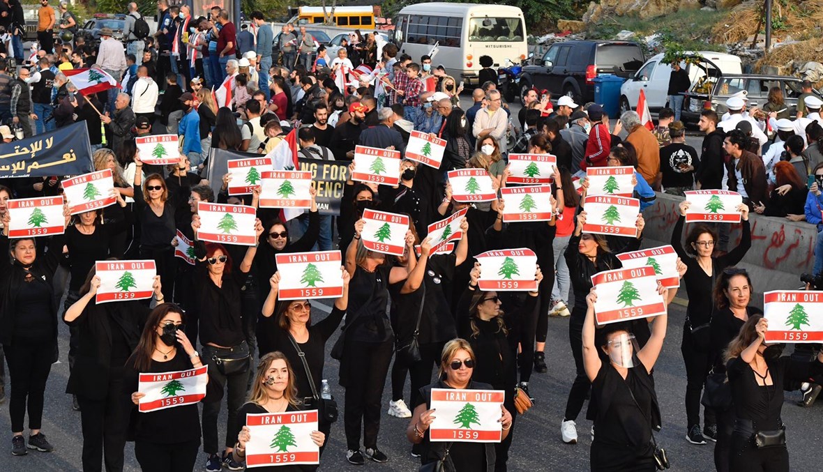 سيدات في العرض المدني يرفعن شعار تطبيق القرار 1559 ودعوة ايران للخروج من لبنان.