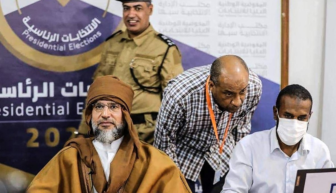 سيف الإسلام القذافي (إلى اليسار) خلال تقديم ترشيحه للانتخابات الرئاسية في سبها جنوب ليبيا (14 ت2 2021، أ ف ب).