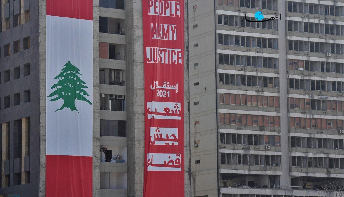 شعار "شعب، جيش، قضاء" رفعه أفراد من المجتمع المدنيّ على واجهة مبنى في محيط مرفأ بيروت بمناسبة عيد الاستقلال (نبيل إسماعيل).