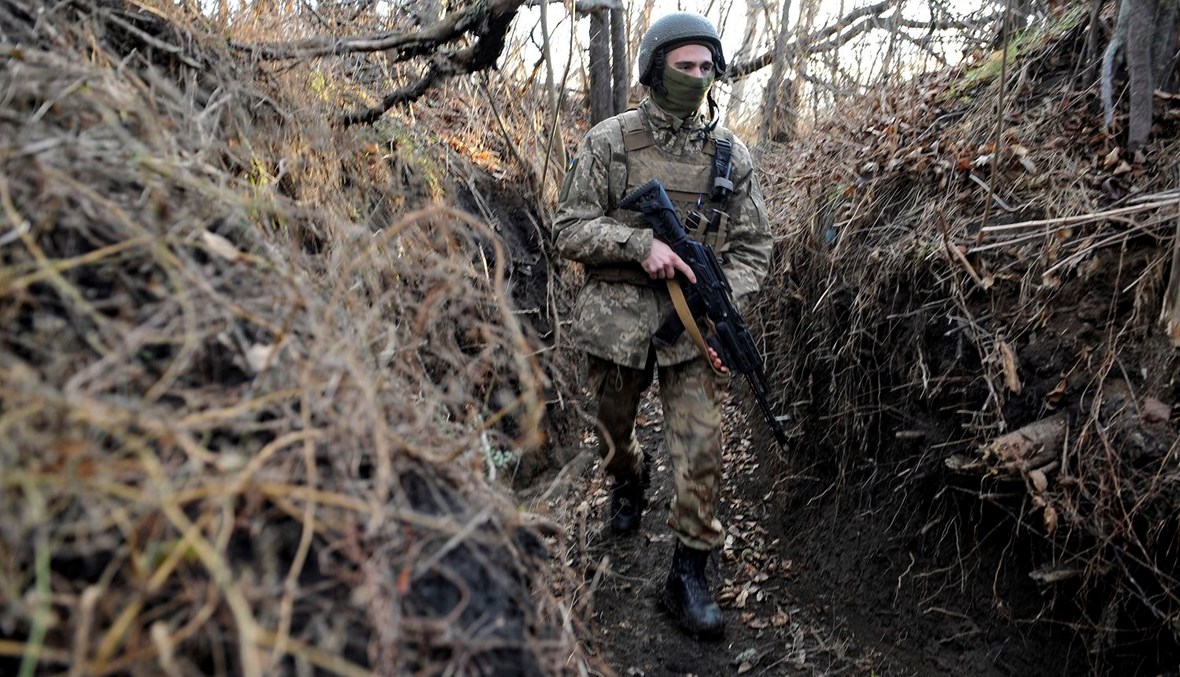 جندي أوكراني يسير على طول خندق على خط المواجهة مع الانفصاليين المدعومين من روسيا بالقرب من قرية تالاكيفكا بمنطقة دونيتسك (أ ف ب).