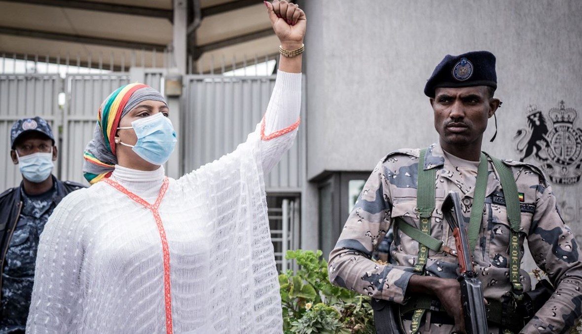 امرأة ترفع قبضتها وهي تردد هتافات، خلال احتجاج على الأخبار الكاذبة المزعومة والتدخل الأجنبي امام مقر السفارة البريطانية في أديس أبابا (25 ت2 2021، أ ف ب). 