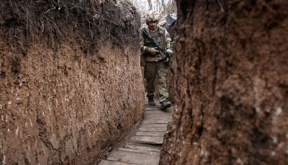 جندي أوكراني يمشي في خندق على خط المواجهة مع الانفصاليين بالقرب من جورليفكا بمنطقة دونيتسك (26 ت2 2021، أ ف ب). 