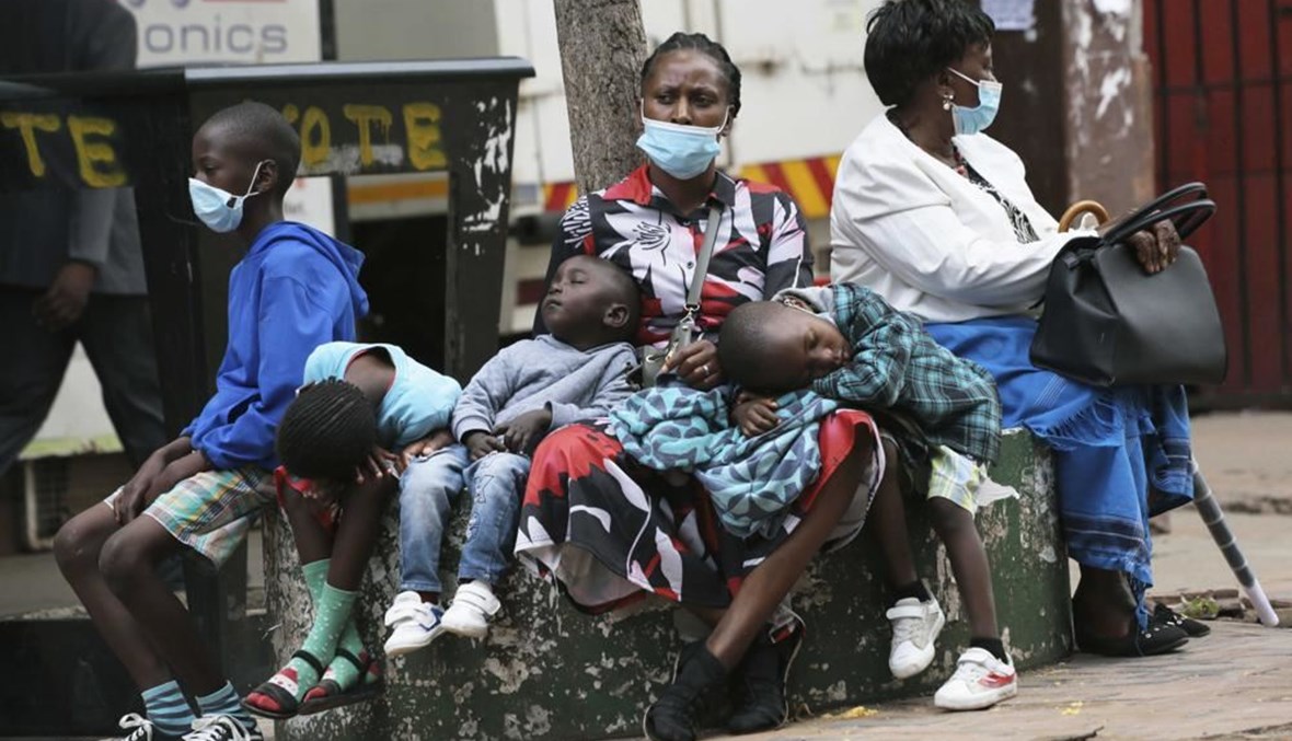 أم تستريح مع أطفالها في هراري بزيمبابوي (26 ت2 2021، أ ب). 