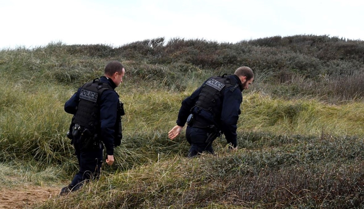 شرطيان يقومان بدورية على شاطئ ويمورو بعد الحادث الذي ادى الى مقتل 27 مهاجرا (25 ت2 2021، أ ف ب). 