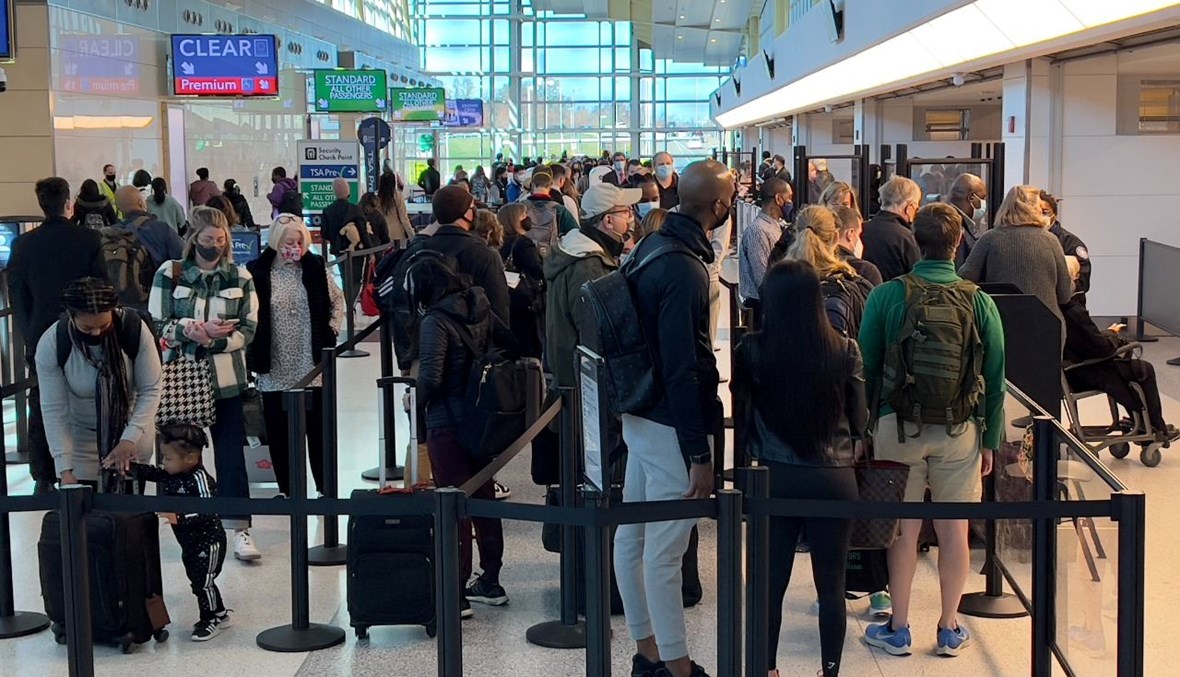 مسافرون يقفون بالصف عند نقطة تفتيش أمنية في مطار واشنطن الوطني بأرلينغتون في فيرجينيا (24 ت2 2021، أ ف ب). 
