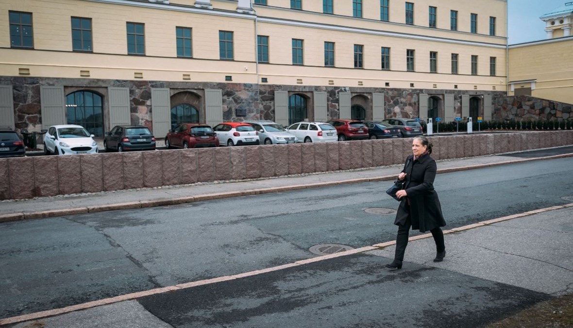 المعلمة تيميلا تمرّ قرب مبنى وزارة الخارجية في هلسنكي (29 ت2 2021، أ ف ب). 