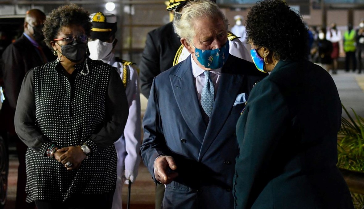 الأمير تشارلز يتحدث الى الرئيسة المنتخبة ساندرا ماسون (الى اليمين) في مطار غرانتلي آدامز الدولي في كريست تشيرش في بربادوس. وبدت رئيسة الوزراء ميا موتلي (الى اليسار) (28 ت2 2021، أ ف ب). 