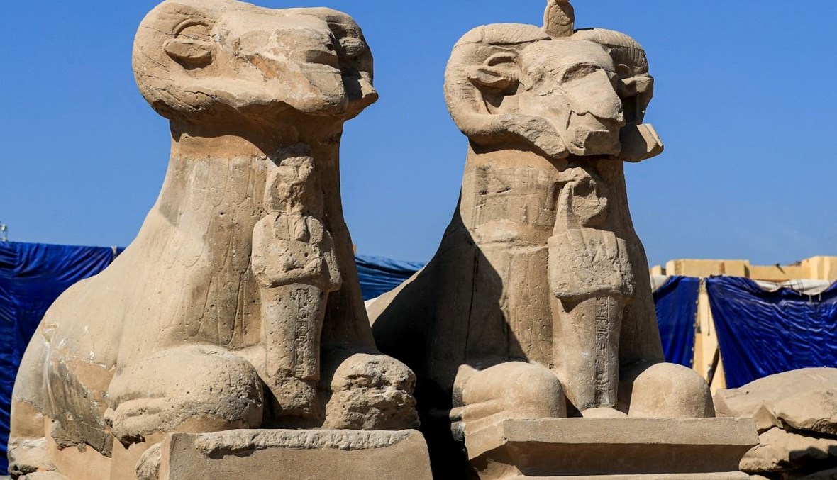 تمثالان لأبي الهول برأس كبش على طريق الكباش قرب معبد الكرنك في مدينة الأقصر جنوب مصر (26 ت2 2021، أ ف ب). 
