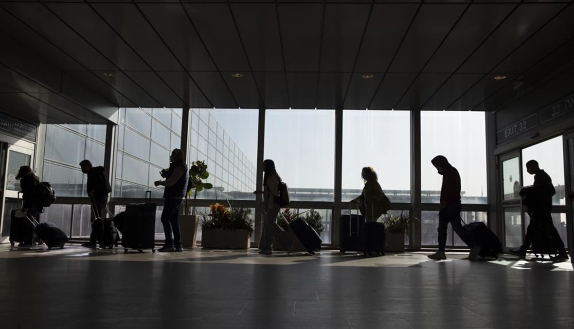 مسافرون يمشون بأمتعتهم في مطار بن غوريون بالقرب من تل أبيب في إسرائيل (28 ت2 2021، أ ب). 