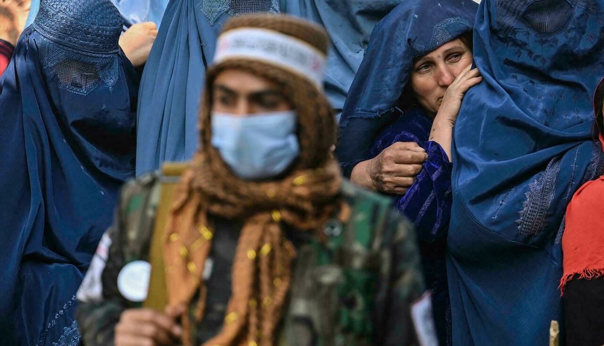 نساء ينتظرن تلقي مساعدات مالية من برنامج الأغذية العالمي في كابول (أ ف ب).