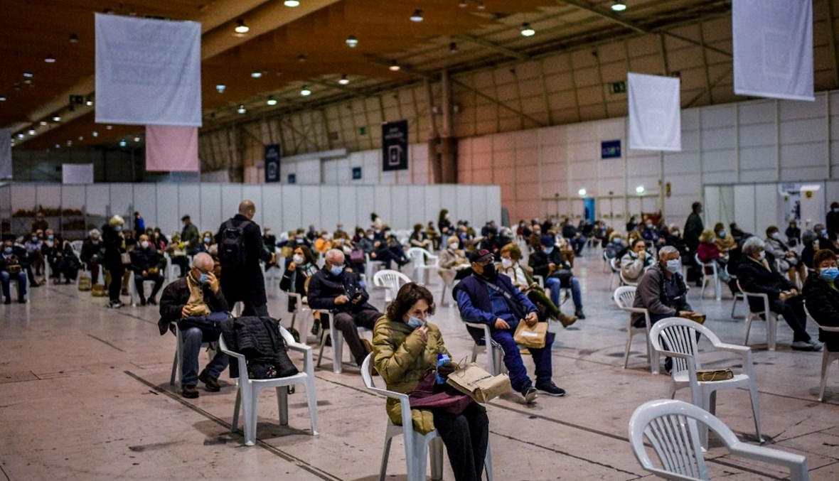 أشخاص جلسوا على كراس في منطقة انتظار بعد تلقيهم جرعة من لقاح كورونا في مركز تطعيم في لشبونة في البرتغال (1 ك1 2021، أ ف ب). 