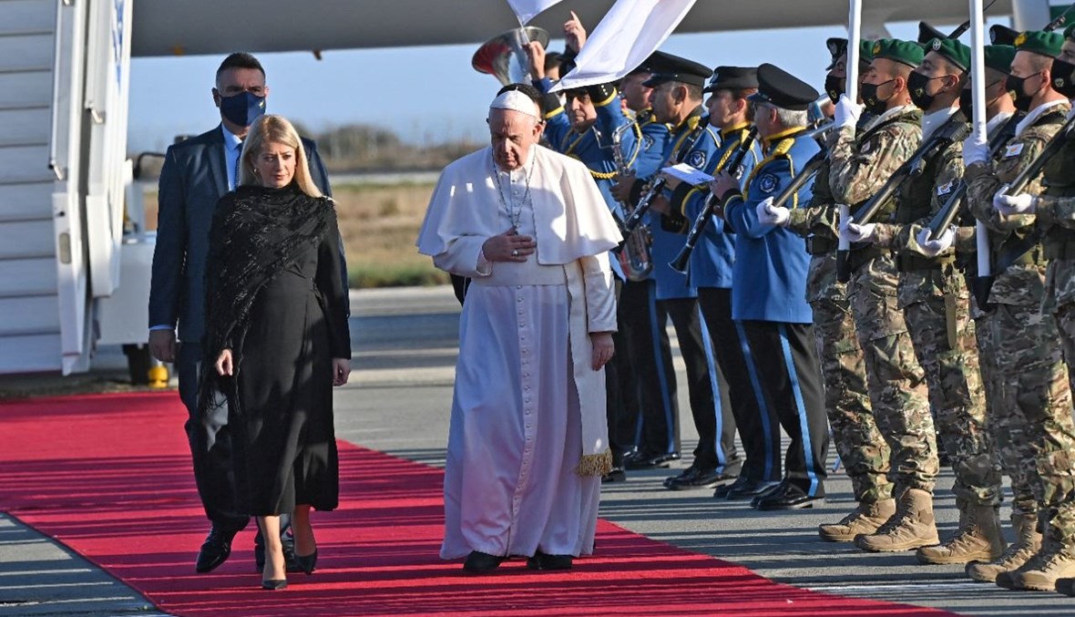 البابا فرنسيس يمشي على السجادة الحمراء مع رئيسة البرلمان القبرصي أنيتا ديميتريو لدى وصوله إلى مدينة لارنكا في قبرص (2 ك1 2021/ أ ف ب). 