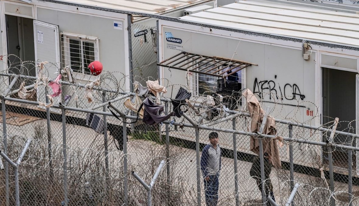 أشخاص في المركز المغلق الجديد للمهاجرين في جزيرة كوس اليونانية (27 ت2 2021، أ ف ب). 