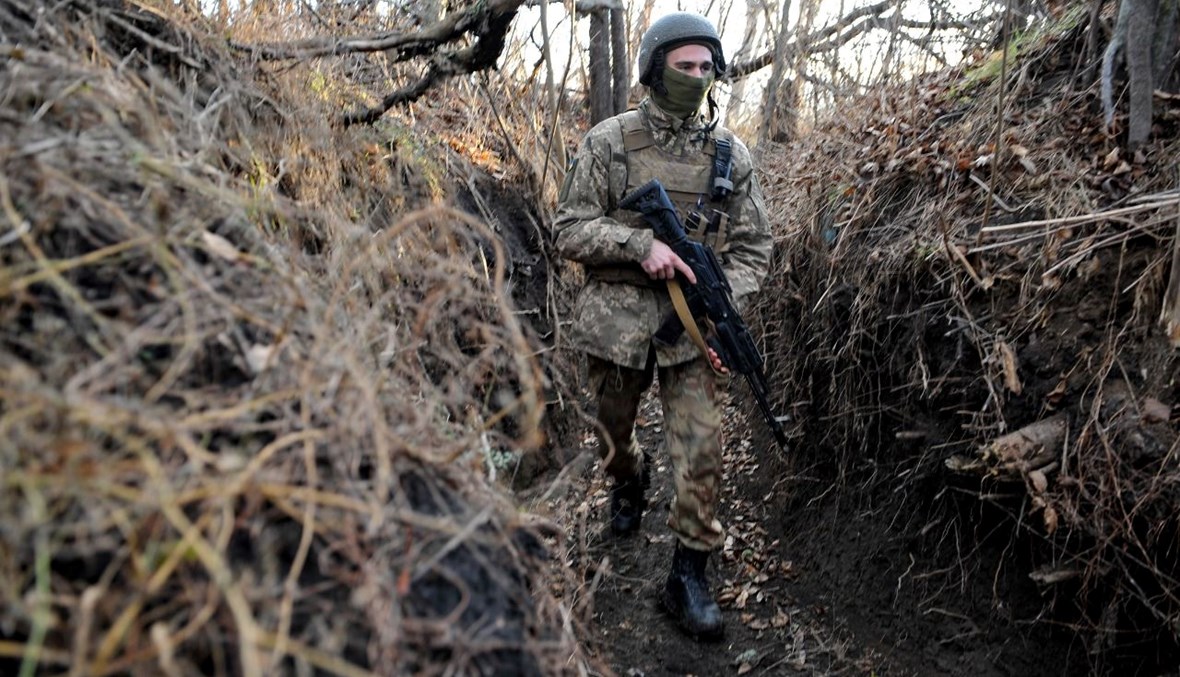 جندي أوكراني يمشي في خندق على خط المواجهة مع الانفصاليين بالقرب من قرية تالاكيفكا بمنطقة دونيتسك (24 ت2 2021، ا ف ب).