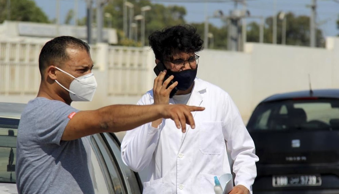 شخصان وقفا خارج مستشفى في تونس العاصمة (21 تموز 2021، أ ب). 